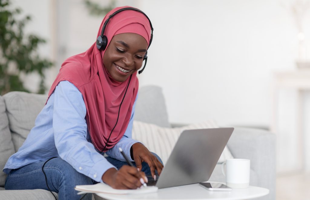 distance learning. black lady in hijab studying online with laptop at home